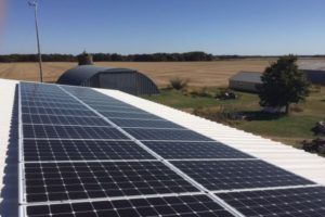 roof mounted solar panels and wind turbine metal barn